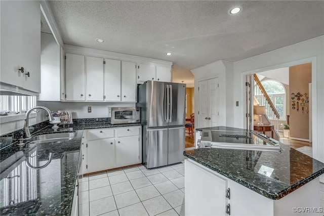 2711 Robson Ct, Henrico, VA 23233 - kitchen featuring appliances with stainless steel finishes, white cabinets, a kitchen island, dark stone counters, and a textured ceiling