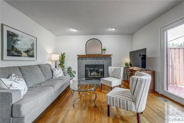 2711 Robson Ct, Henrico, VA 23233 - living area with wood finished floors, a tiled fireplace, and a textured ceiling