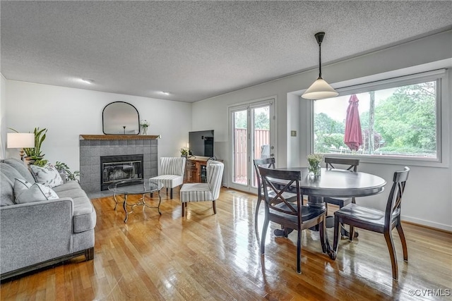 2711 Robson Ct, Henrico, VA 23233 - dining space featuring a tiled fireplace, a textured ceiling, and wood finished floors