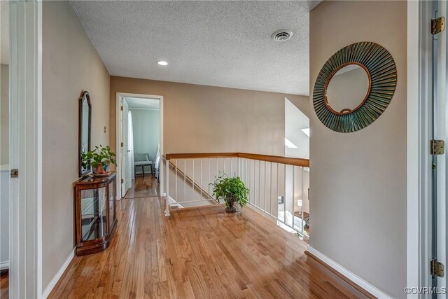 2711 Robson Ct, Henrico, VA 23233 - hall with wood finished floors, a textured ceiling, and an upstairs landing