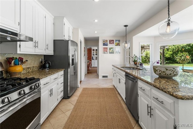 8950 Bellefonte Rd, Henrico, VA 23229 - kitchen with under cabinet range hood, stainless steel appliances, white cabinets, light tile patterned floors, and recessed lighting