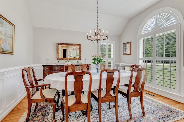 8467 Wendellshire Way, Mechanicsville, VA 23111 - dining space featuring light wood-type flooring, a chandelier, lofted ceiling, wainscoting, and a decorative wall