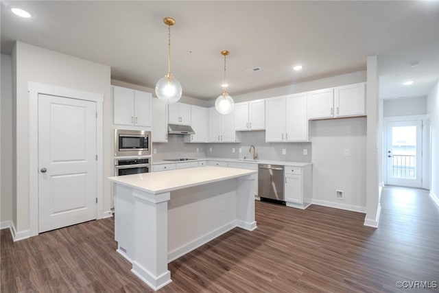 3436 Carlton St Unit 4-4A, Richmond, VA 23230 - kitchen with appliances with stainless steel finishes, under cabinet range hood, dark wood-style floors, a kitchen island, and white cabinetry