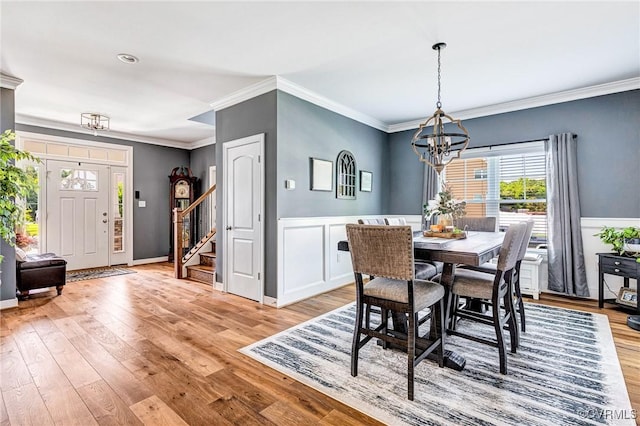 9401 Alsace Ct, Mechanicsville, VA 23116 - dining space featuring a chandelier, light wood-style floors, stairs, crown molding, and wainscoting