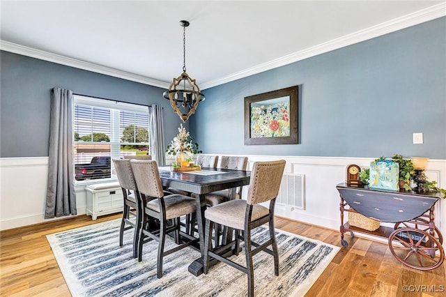 9401 Alsace Ct, Mechanicsville, VA 23116 - dining room with crown molding, a chandelier, light wood-style floors, and wainscoting
