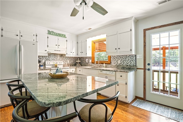 15615 Providence Rd, Prince George, VA 23805 - kitchen featuring white appliances, a breakfast bar, white cabinetry, light wood-type flooring, and tasteful backsplash