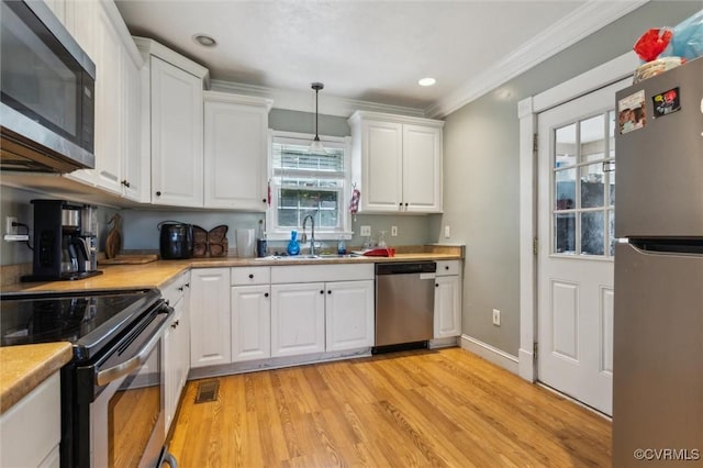3608 Shell Rd, Newport News, VA 23661 - kitchen with appliances with stainless steel finishes, white cabinets, light countertops, light wood-style flooring, and crown molding