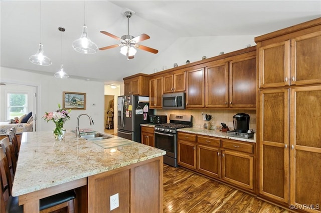112 Rosemary Ct, Tappahannock, VA 22560 - kitchen with appliances with stainless steel finishes, a ceiling fan, brown cabinetry, vaulted ceiling, and a kitchen bar