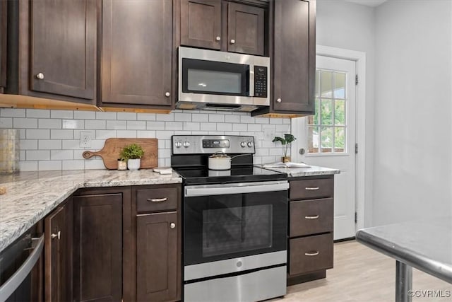 1808 N 20th St, Richmond, VA 23223 - kitchen featuring stainless steel appliances, dark brown cabinetry, decorative backsplash, light wood-style flooring, and light stone counters