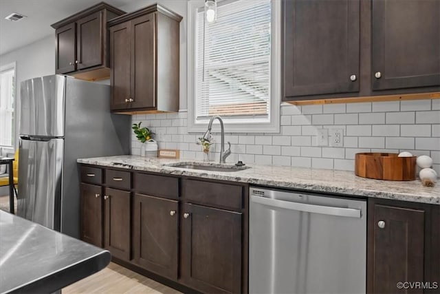 1808 N 20th St, Richmond, VA 23223 - kitchen featuring stainless steel appliances, dark brown cabinetry, healthy amount of natural light, and decorative backsplash