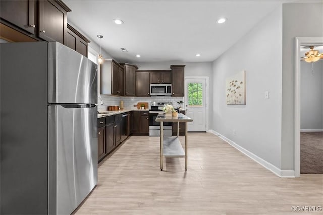 1808 N 20th St, Richmond, VA 23223 - kitchen with stainless steel appliances, dark brown cabinets, tasteful backsplash, light wood-style floors, and recessed lighting