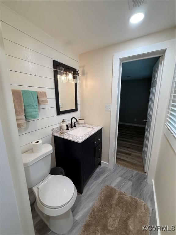 616 Long Point Ln, Topping, VA 23169 - bathroom with vanity, wood finished floors, and wooden walls