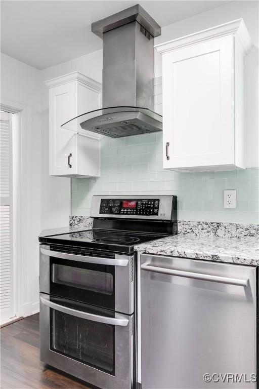 2149 Park Ln, Henrico, VA 23230 - kitchen featuring appliances with stainless steel finishes, extractor fan, white cabinetry, tasteful backsplash, and light stone countertops