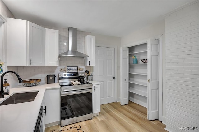 7709 Yolanda Rd, Henrico, VA 23229 - kitchen with stainless steel range with electric stovetop, wall chimney range hood, white cabinetry, tasteful backsplash, and light countertops