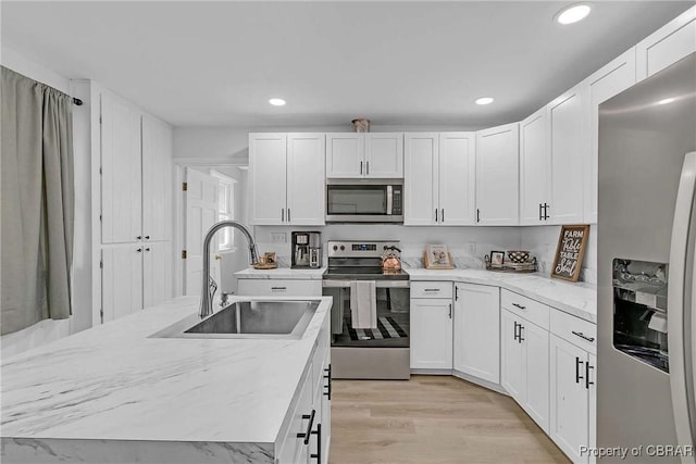 7284 Farinholt St, Gloucester, VA 23061 - kitchen with stainless steel appliances, white cabinetry, recessed lighting, light wood-type flooring, and light stone countertops