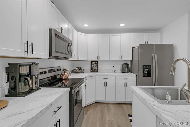 7284 Farinholt St, Gloucester, VA 23061 - kitchen featuring stainless steel appliances, white cabinetry, light wood-style floors, light stone countertops, and recessed lighting