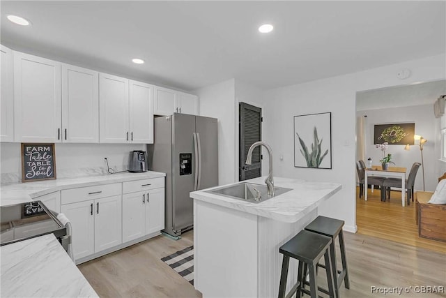 7284 Farinholt St, Gloucester, VA 23061 - kitchen with stainless steel refrigerator with ice dispenser, range, light wood-type flooring, white cabinets, and recessed lighting