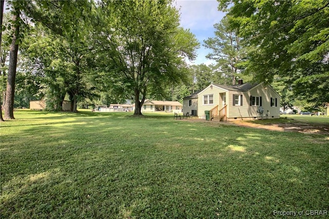 7284 Farinholt St, Gloucester, VA 23061 - view of green lawn with entry steps and view of wooded area