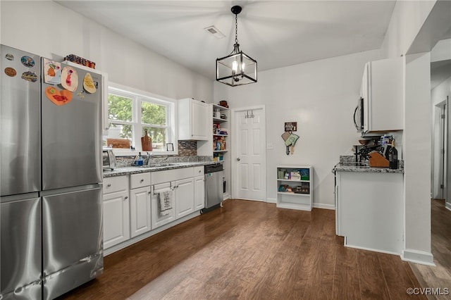 3315 Romancoke Ave, West Point, VA 23181 - kitchen featuring appliances with stainless steel finishes, a chandelier, dark wood-type flooring, light stone counters, and white cabinetry