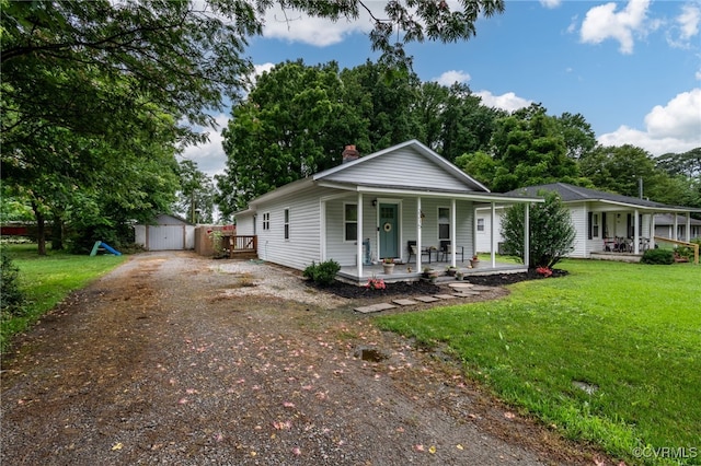 3315 Romancoke Ave, West Point, VA 23181 - view of front facade with covered porch, dirt driveway, a front yard, and a shed