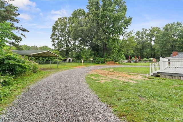 8467 Shady Grove Rd, Mechanicsville, VA 23116 - surrounding community with a detached carport, a wooden deck, gravel driveway, and view of wooded area