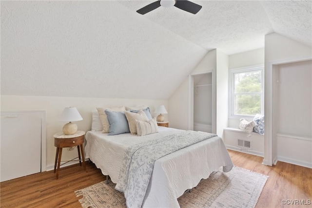 8467 Shady Grove Rd, Mechanicsville, VA 23116 - bedroom with a textured ceiling, vaulted ceiling, light wood finished floors, and ceiling fan