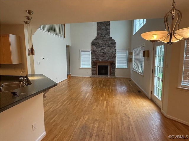 14005 Cooperton Cir, Chester, VA 23836 - unfurnished living room featuring light wood-style floors, a towering ceiling, and a stone fireplace