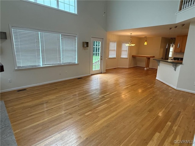 14005 Cooperton Cir, Chester, VA 23836 - unfurnished living room with a high ceiling, light wood-type flooring, and a chandelier