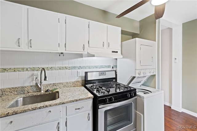 21 Rock Garden Ln, Henrico, VA 23228 - kitchen featuring stainless steel range with gas cooktop, stacked washer and clothes dryer, under cabinet range hood, dark wood-type flooring, and white cabinetry