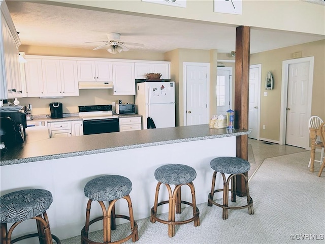 4030 Wellfords Wharf Rd, Warsaw, VA 22572 - kitchen featuring range with electric stovetop, freestanding refrigerator, under cabinet range hood, a breakfast bar area, and a peninsula
