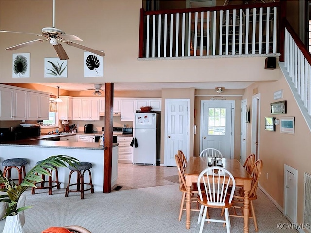 4030 Wellfords Wharf Rd, Warsaw, VA 22572 - dining room with ceiling fan, a high ceiling, and stairs