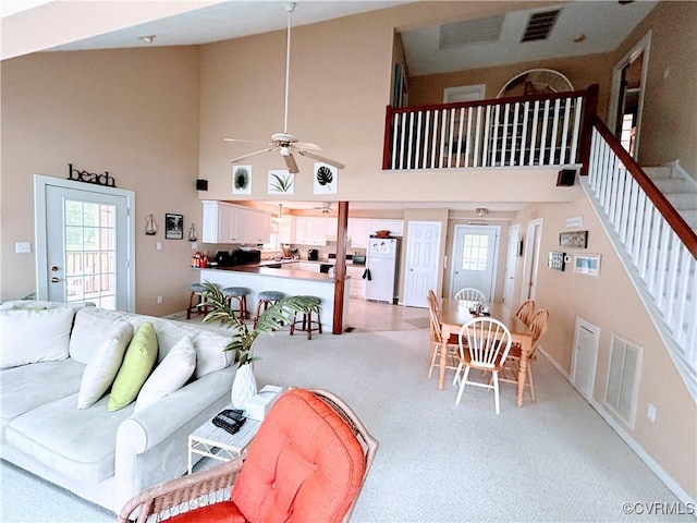 4030 Wellfords Wharf Rd, Warsaw, VA 22572 - living room with a high ceiling, a ceiling fan, stairs, and light colored carpet