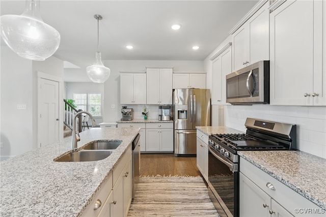 6906 Stafford Park Dr, Moseley, VA 23120 - kitchen featuring stainless steel appliances, wood finished floors, decorative light fixtures, backsplash, and white cabinets