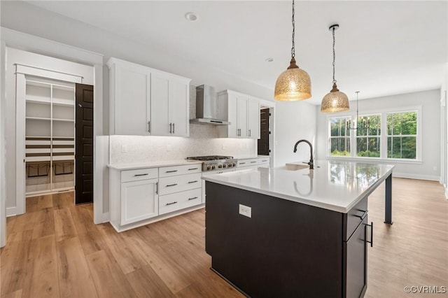 5-6 Pocahontas Trl, Providence Forge, VA 23089 - kitchen featuring wall chimney range hood, stainless steel gas cooktop, light countertops, light wood-type flooring, and decorative backsplash