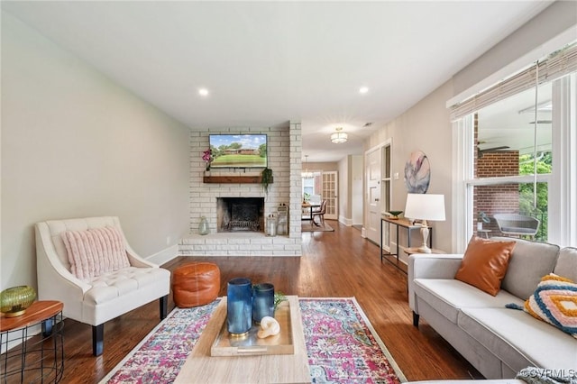 610 N 39th St, Richmond, VA 23223 - living room featuring wood finished floors, plenty of natural light, a brick fireplace, and recessed lighting