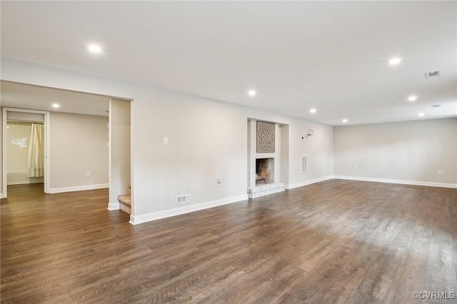 610 N 39th St, Richmond, VA 23223 - unfurnished living room with recessed lighting, wood finished floors, a fireplace with raised hearth, and stairway