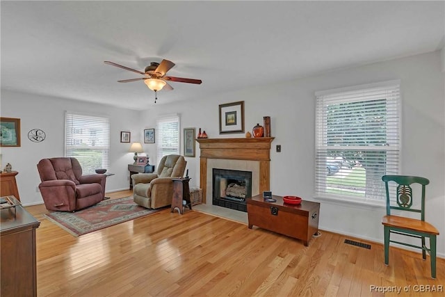 6661 Powhatan Dr, Hayes, VA 23072 - living room with a fireplace with flush hearth, light wood-style flooring, and a ceiling fan