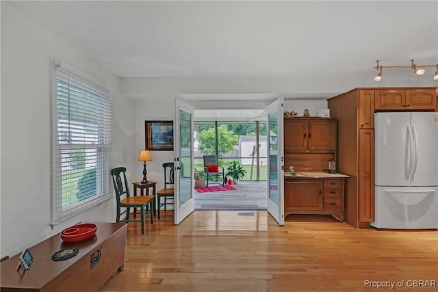 6661 Powhatan Dr, Hayes, VA 23072 - kitchen featuring freestanding refrigerator, light wood-style floors, and brown cabinetry