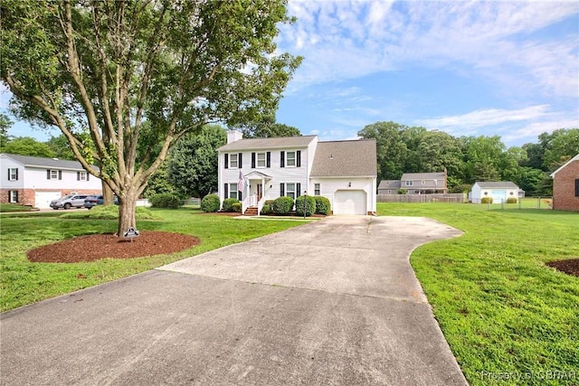 6661 Powhatan Dr, Hayes, VA 23072 - colonial home featuring concrete driveway, an attached garage, and a chimney