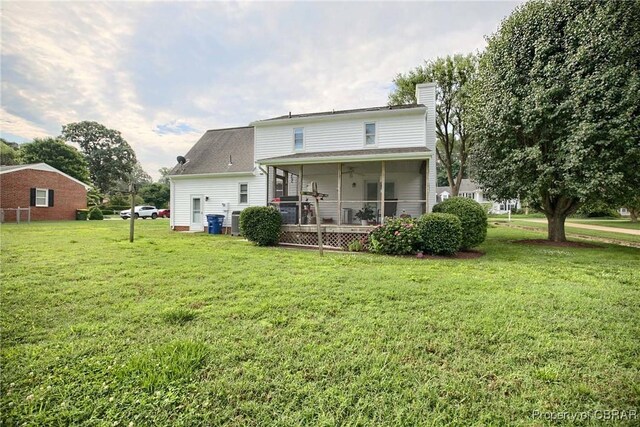 6661 Powhatan Dr, Hayes, VA 23072 - back of house with a chimney, a lawn, and a sunroom