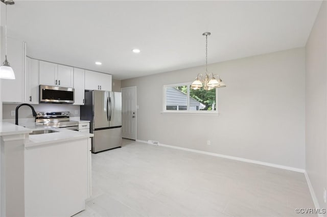 8238 Lansdowne Rd, Mechanicsville, VA 23116 - kitchen with stainless steel appliances, light countertops, a chandelier, white cabinets, and pendant lighting