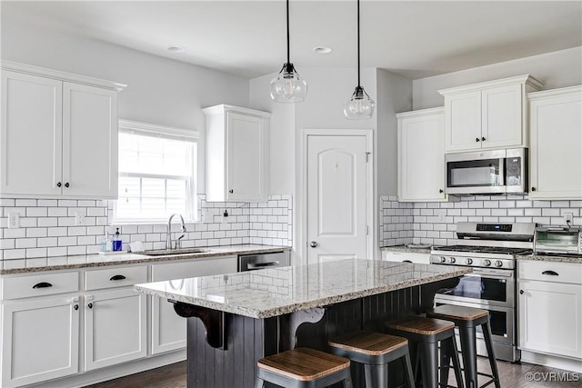 14812 Diamond Creek Ter, Chesterfield, VA 23113 - kitchen with appliances with stainless steel finishes, white cabinetry, a breakfast bar area, a center island, and light stone counters