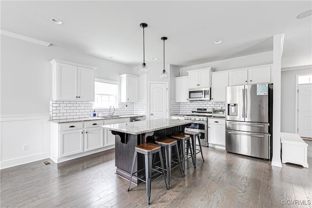 14812 Diamond Creek Ter, Chesterfield, VA 23113 - kitchen with stainless steel appliances, a center island, a breakfast bar, white cabinetry, and light stone counters