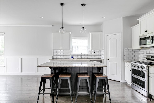 14812 Diamond Creek Ter, Chesterfield, VA 23113 - kitchen featuring stainless steel appliances, a breakfast bar, a kitchen island, white cabinets, and a wainscoted wall