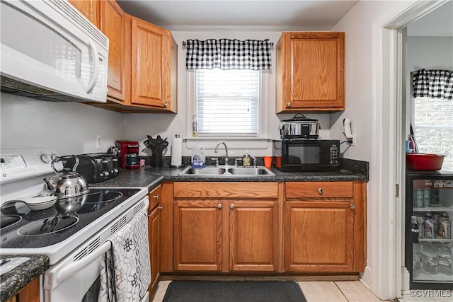 18 E 36th St, Richmond, VA 23224 - kitchen featuring white appliances, dark countertops, and brown cabinetry