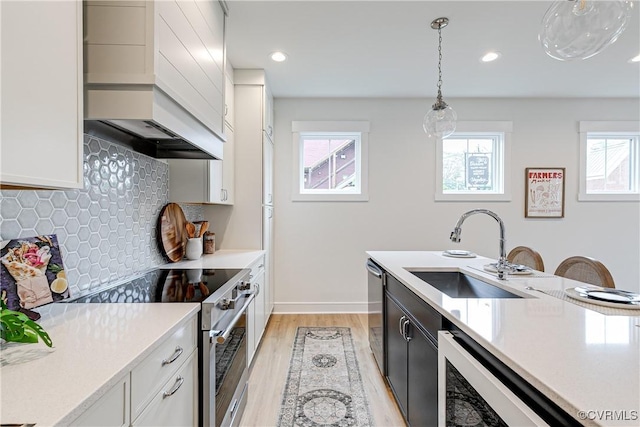 1823 W Cary St Unit A, Richmond, VA 23220 - kitchen featuring appliances with stainless steel finishes, light countertops, decorative backsplash, light wood-type flooring, and hanging light fixtures
