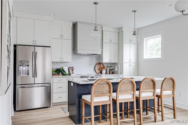 1823 W Cary St Unit A, Richmond, VA 23220 - kitchen with stainless steel fridge, custom range hood, light countertops, decorative backsplash, and light wood-type flooring