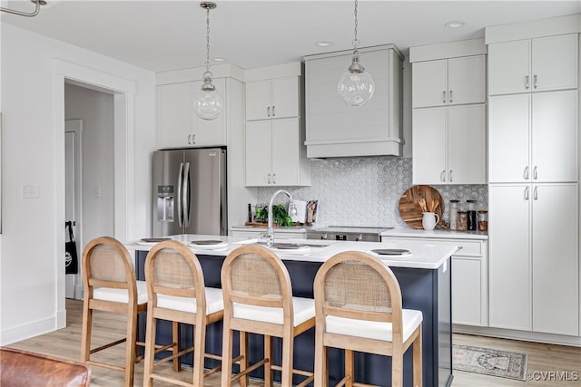 1823 W Cary St Unit A, Richmond, VA 23220 - kitchen featuring stainless steel fridge with ice dispenser, a kitchen island with sink, light countertops, custom range hood, and light wood finished floors