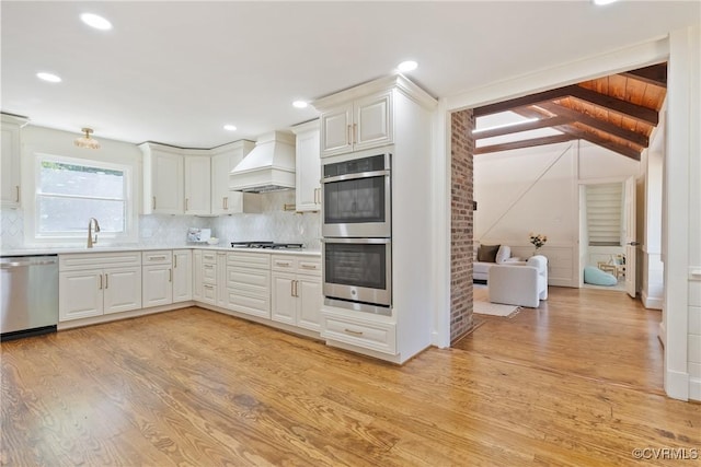 13511 W Salisbury Rd, Chesterfield, VA 23113 - kitchen with appliances with stainless steel finishes, custom exhaust hood, light countertops, tasteful backsplash, and light wood-style floors