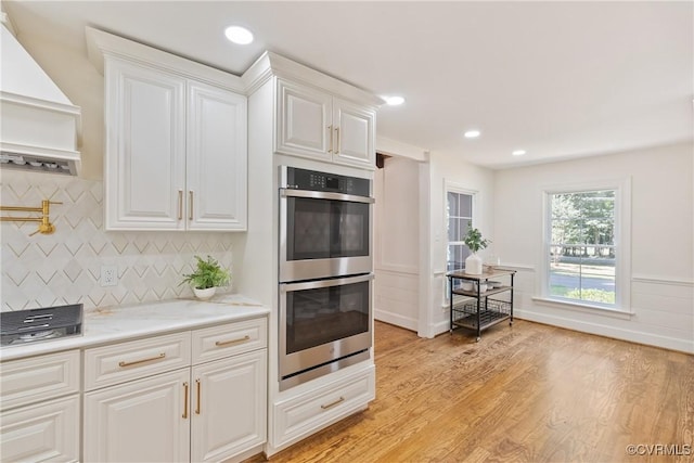13511 W Salisbury Rd, Chesterfield, VA 23113 - kitchen featuring stainless steel double oven, white cabinets, premium range hood, light wood-type flooring, and recessed lighting